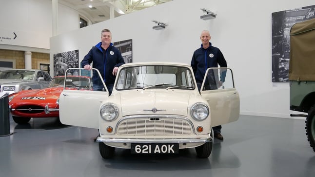 Two representatives of Peter James Insurance stood next to Morris Mini-Minor Number One 